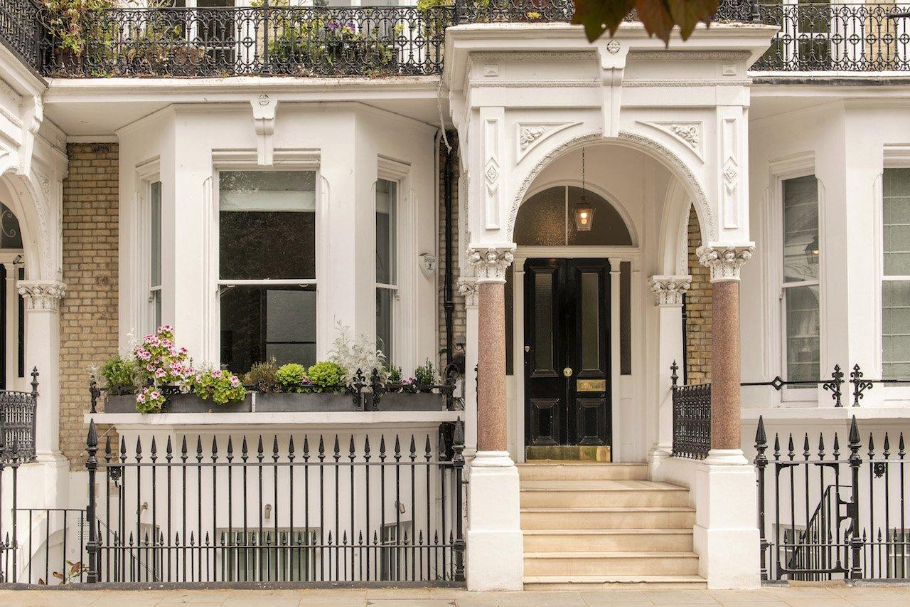 Elegant London townhouse with ornate white entrance and black door